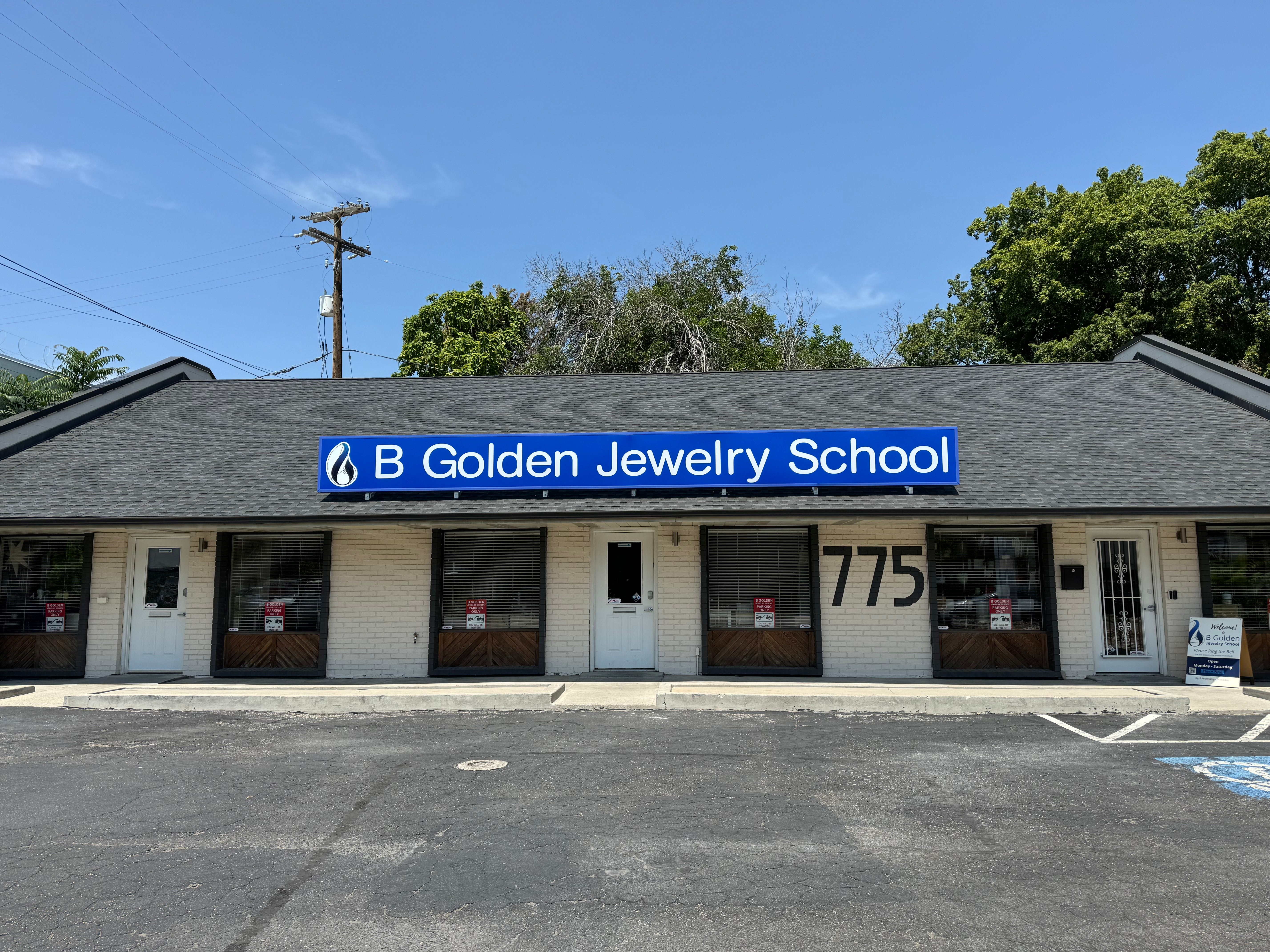 B Golden Jewelry School building with a blue sign on a clear day